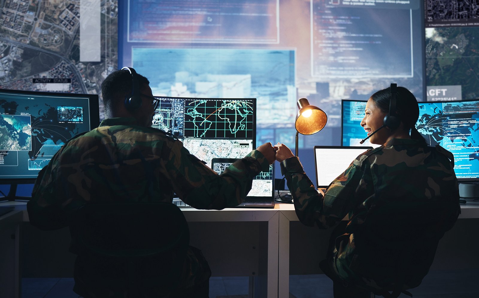 Control room, military and fist bump by soldier team on surveillance together at night for communication. Technology, global and teamwork by security with success on satellite map in army office cyber warriors on TDY